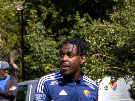 Joel Asoro i Djurgårdens blå träningströja utomhus, med träd i bakgrunden.